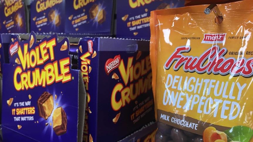 Violet Crumble bars next to a packet of FruChocs.