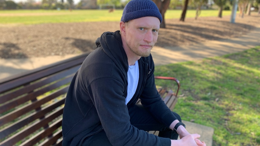 A man sits on a park bench.