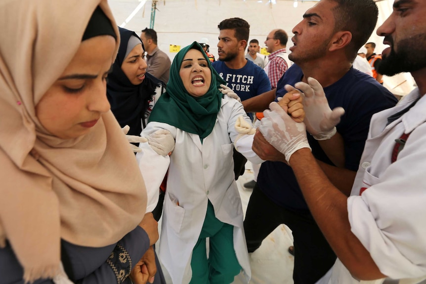 A Palestinian woman is seen reacting in shock upon seeing the body of her husband.