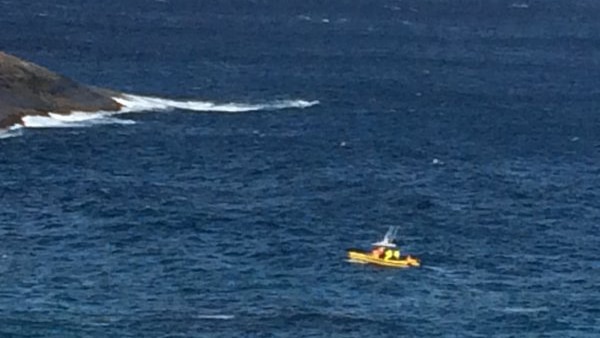 A boat from Albany Volunteer Marine Rescue travels along the blue water off rocks near Albany.
