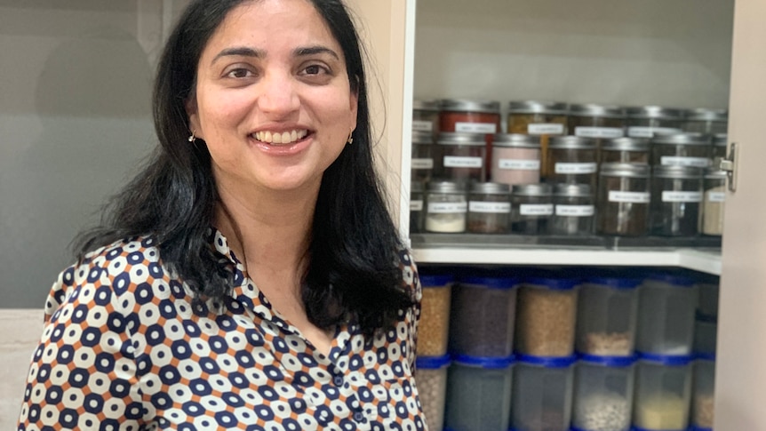 Simran Singh standing in front of her pantry at home