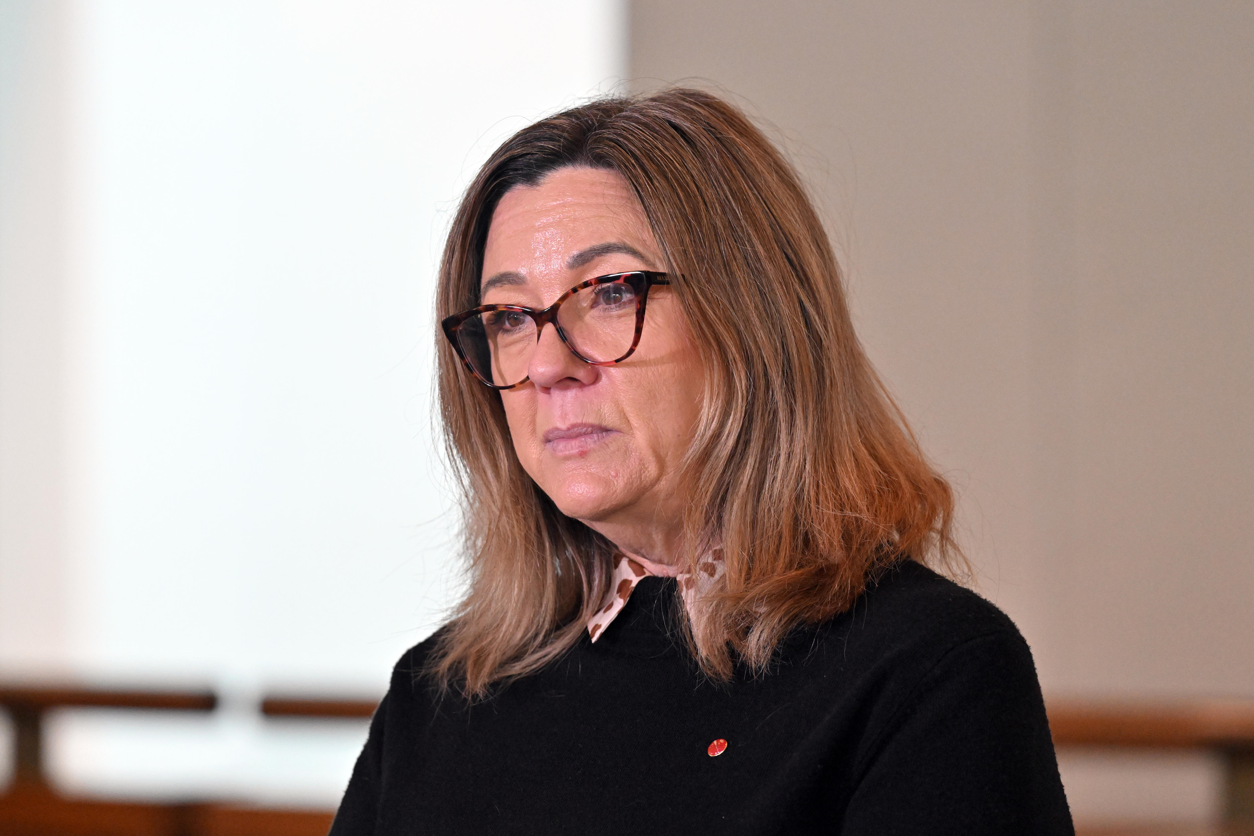 A woman looks stern in glasses 