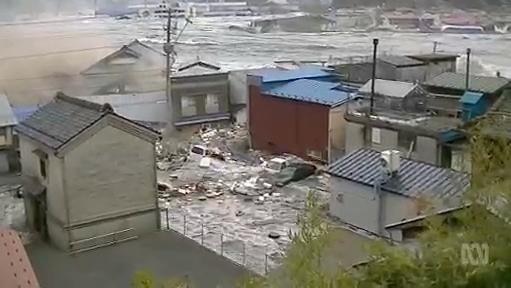 Tsunami wave crashes around houses