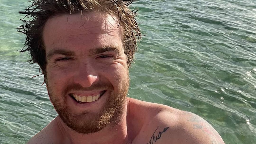 A man poses for a selfie in the ocean