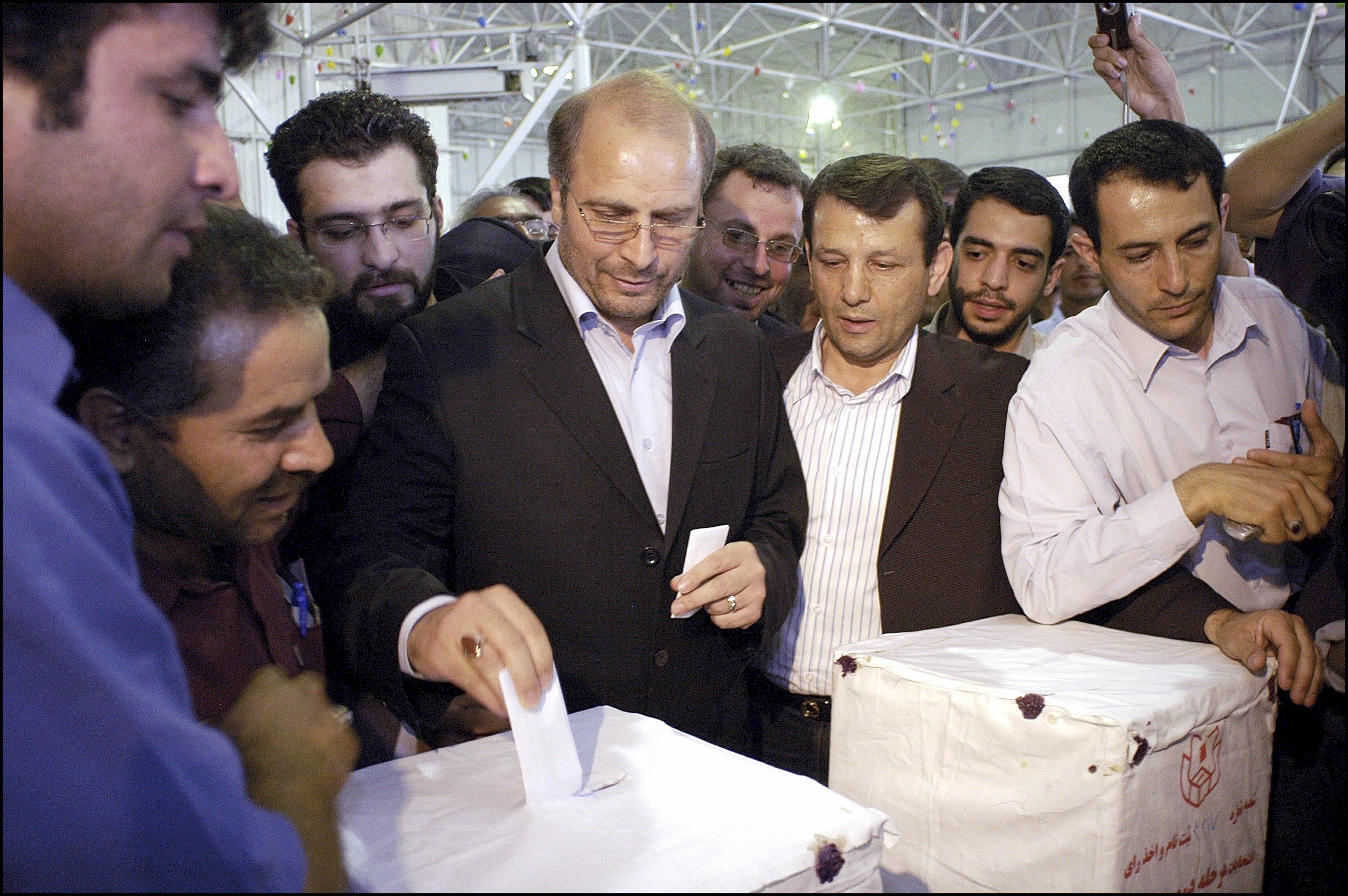 Mohammad Baqer Qalibaf casts his vote with Iranians watching on.