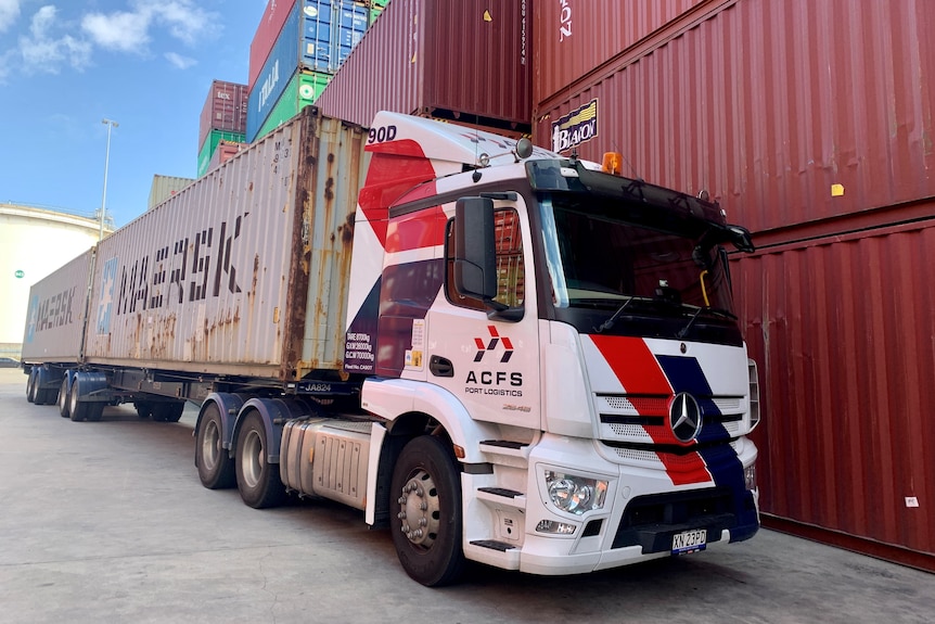 An ACFS truck carries two Maersk shipping containers in front of a stack of other containers at Sydney's Port Botany.