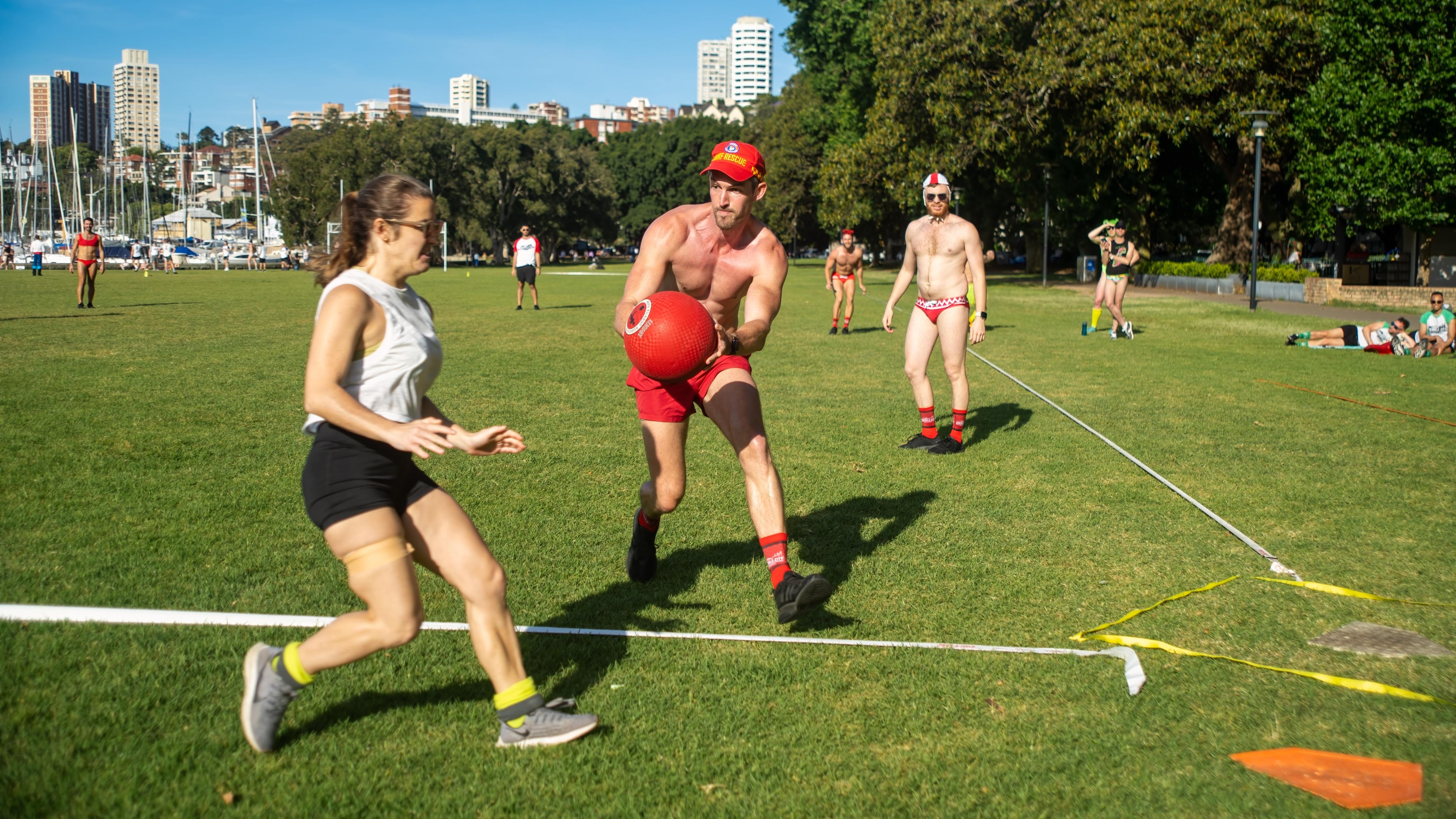 A woman runs towards a base while a man comes towards her with the ball.