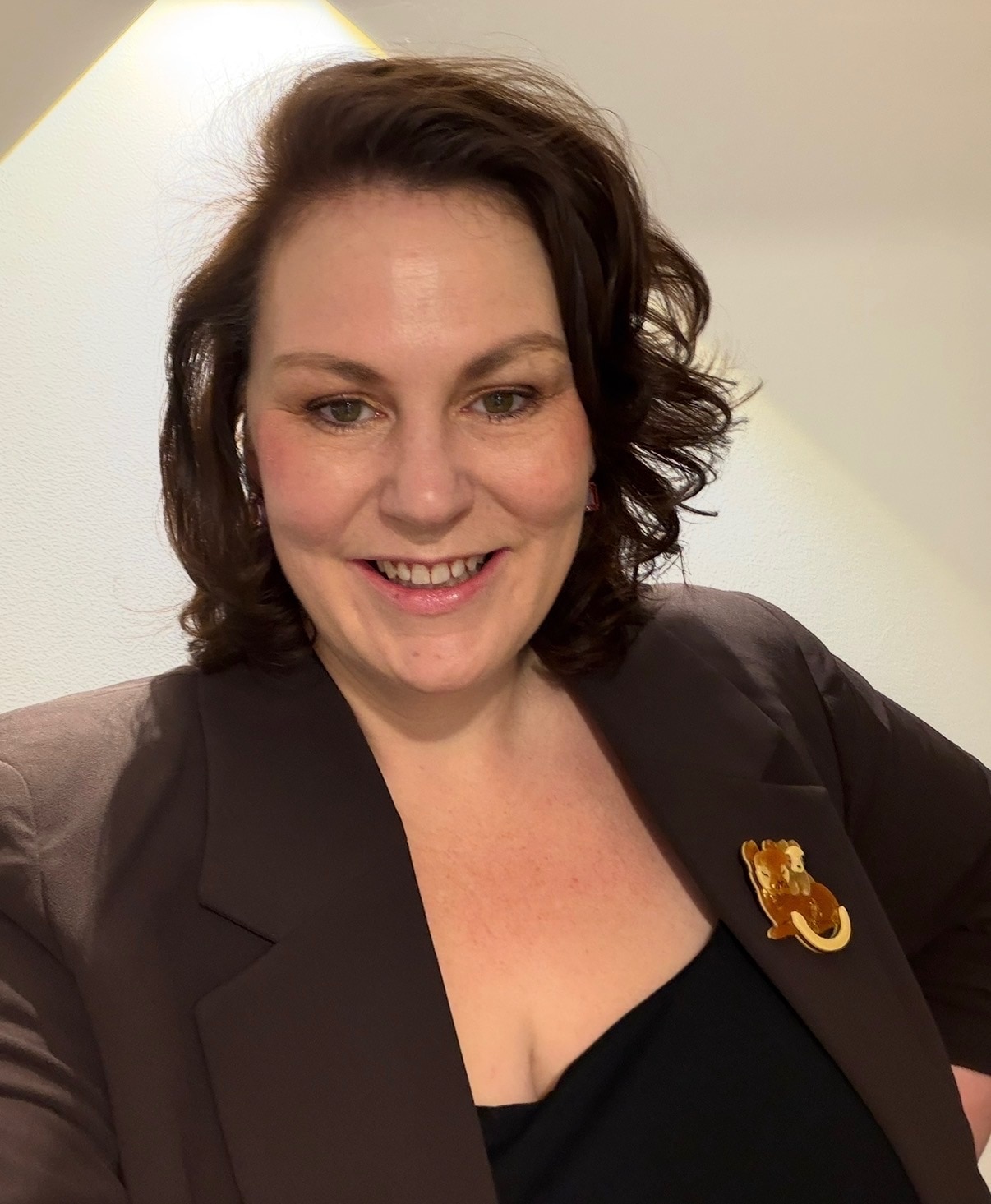 A dark-haired woman smiles for a selfie.