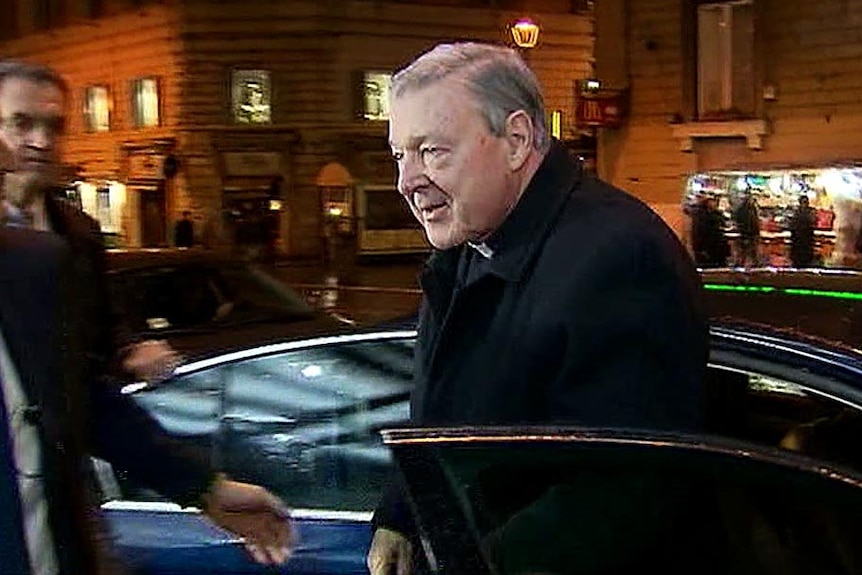 Cardinal George Pell gets out of a car as he arrives at the Hotel Quirinale in Rome at night.