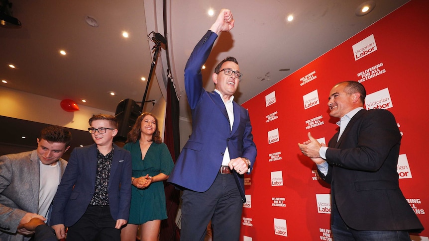 Daniel Andrews lifts a fist into the air as he goes on stage at Labor's election party.