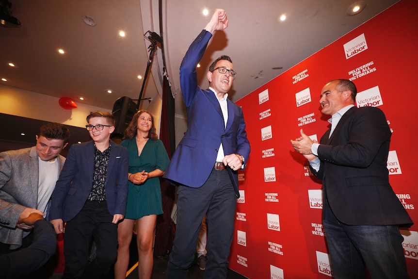 Daniel Andrews lifts a fist into the air as he goes on stage at Labor's election party.