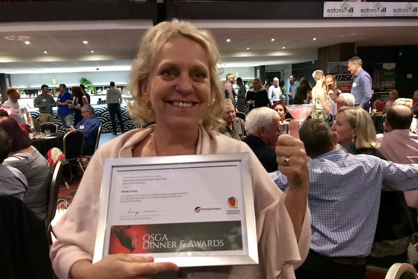 Mandy Shultz holds up her award at the Association's annual dinner.