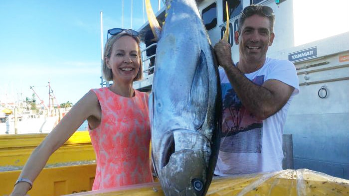 A couple poses with a big tuna.
