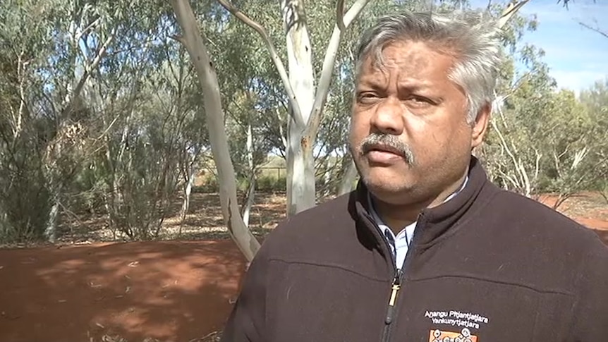 APY Lands manager Richard King standing in front of a tree wearing a black jumper