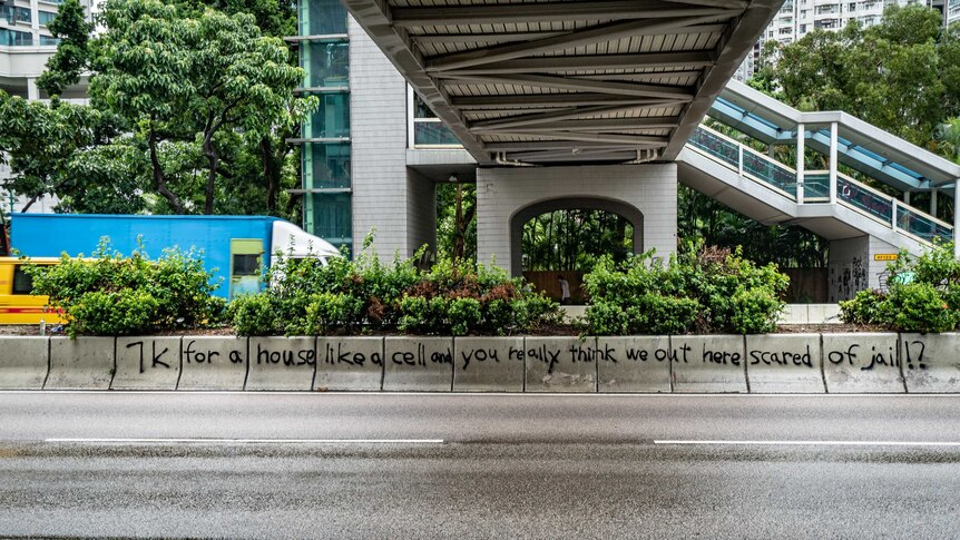 Graffti on a Hong Kong street pillar read: 7K for a house like a cell and you really think that we are scared of jail?