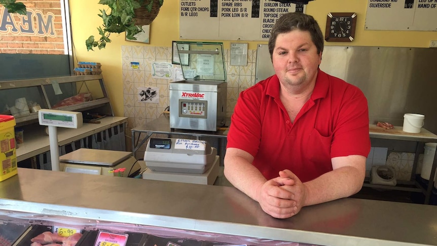 Mark Woolfe leaning on his butcher's counter