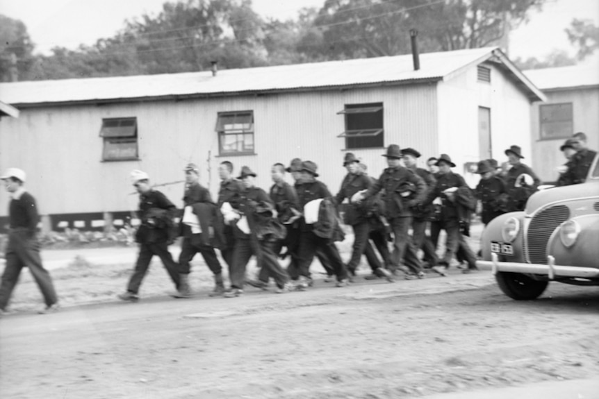 Japanese prisoners of war marching in camp.