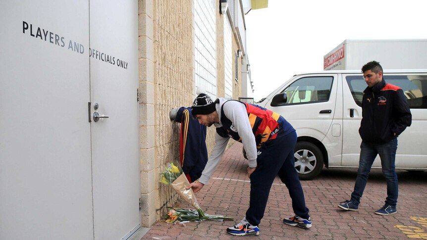 Adelaide Crows fans place flowers at the club's headquarters