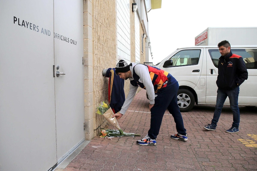 Adelaide Crows fans place flowers at the club's headquarters