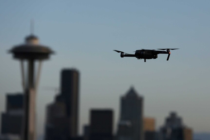 A drone hovers at a viewpoint overlooking the Space Needle and skyline of Seattle, Washington.