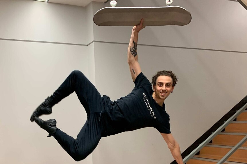 Marcus Morelli, a ballet dancer, leaps into the air with a skateboard over his head.