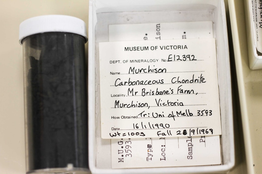 A vial of coal-like substance and a note stating 'Mr Brisbane's farm'