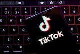The TikTok logo hovering over a keyboard.