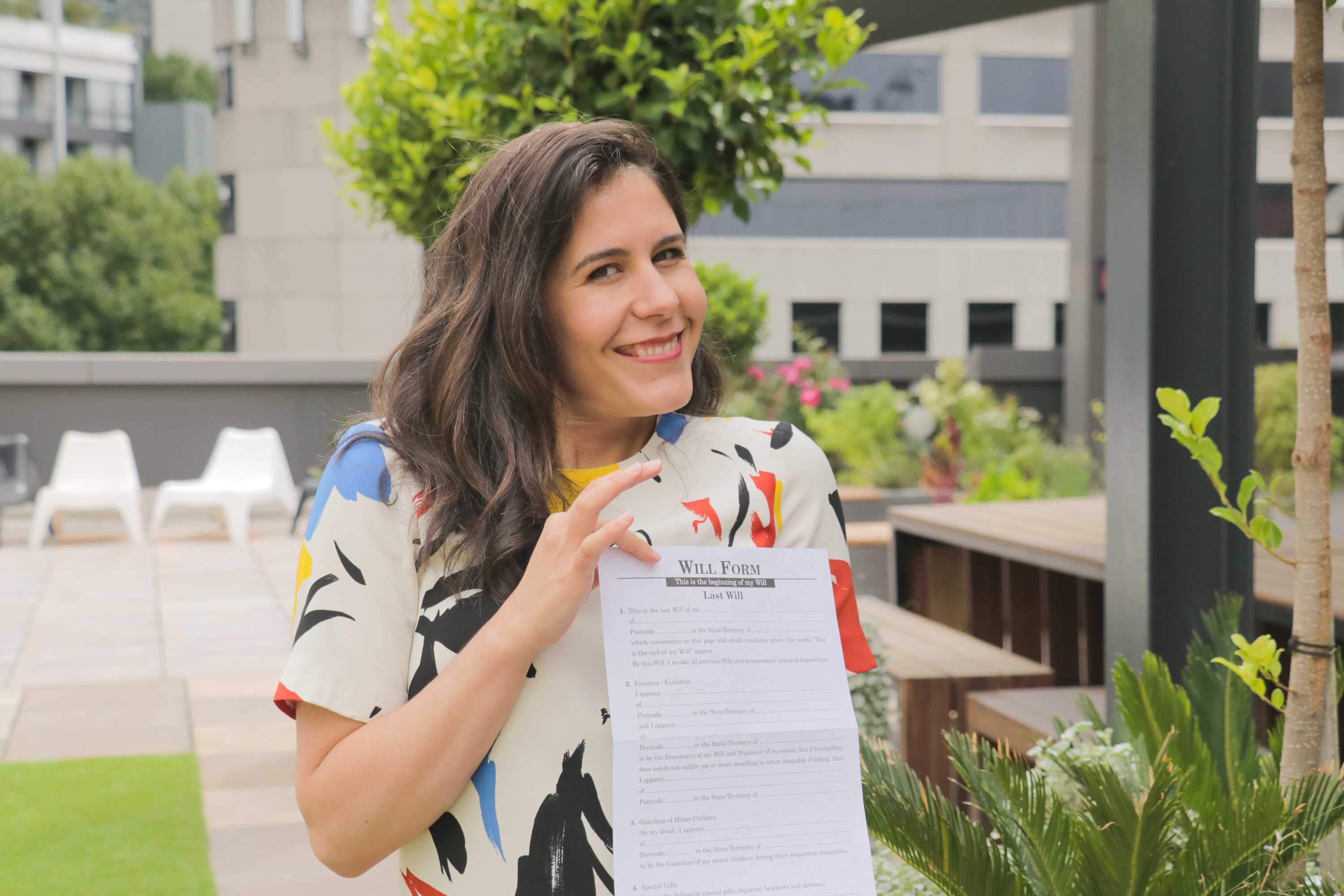 Jan Fran holding a will form and smiling to the camera.