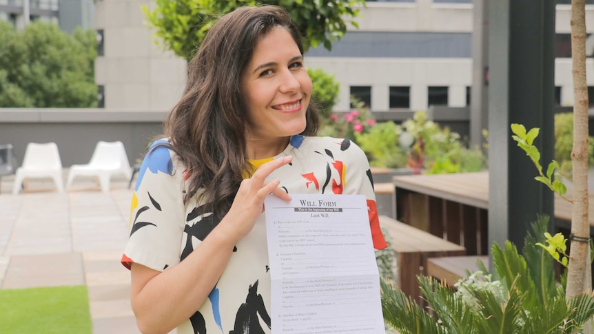 Jan Fran holding a will form and smiling to the camera.