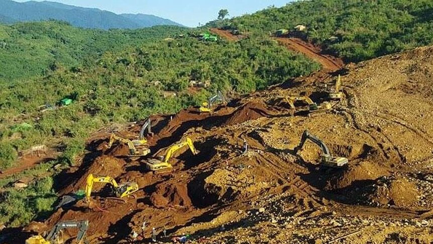 Rescue teams search for the bodies of miners killed in a landslide