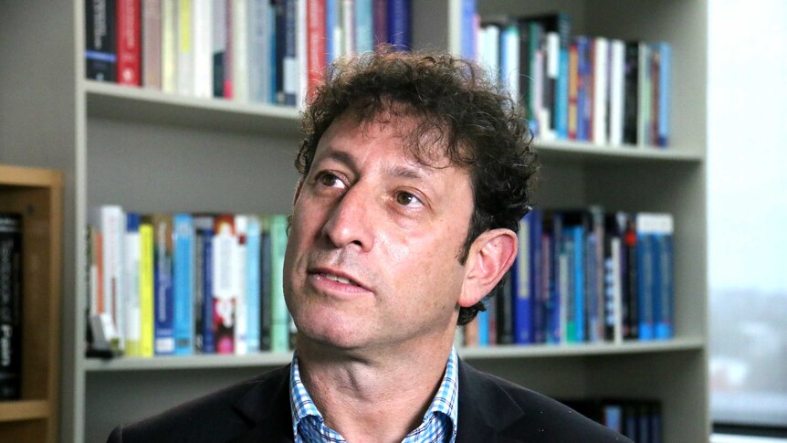 Dan Lubman sits in an office in front of a bookshelf.