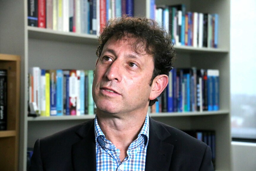 Dan Lubman sits in an office in front of a bookshelf.