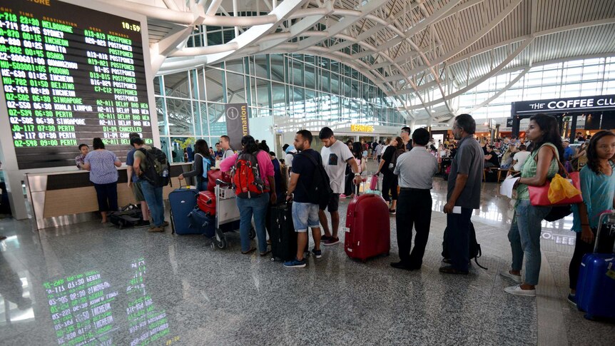 Passengers queue at Denpasar airport