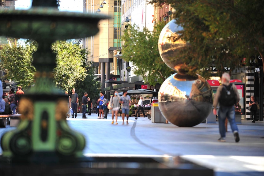 People wearing face masks walk through Adelaide's Rundle Mall.