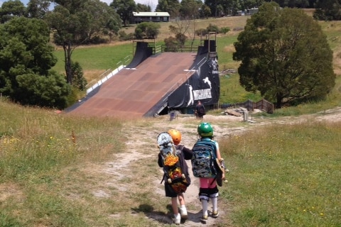Two children with skateboards head towards Peter Wilson's skate ramp, in Gippsland.