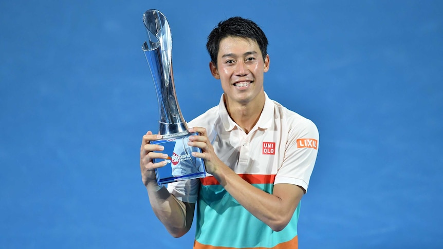 Japan's Kei Nishikori holds Brisbane International trophy after winning final on January 6, 2019.