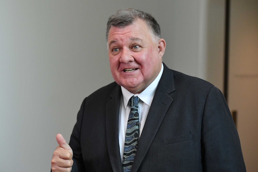 Older man wearing black suit and colourful blue tie