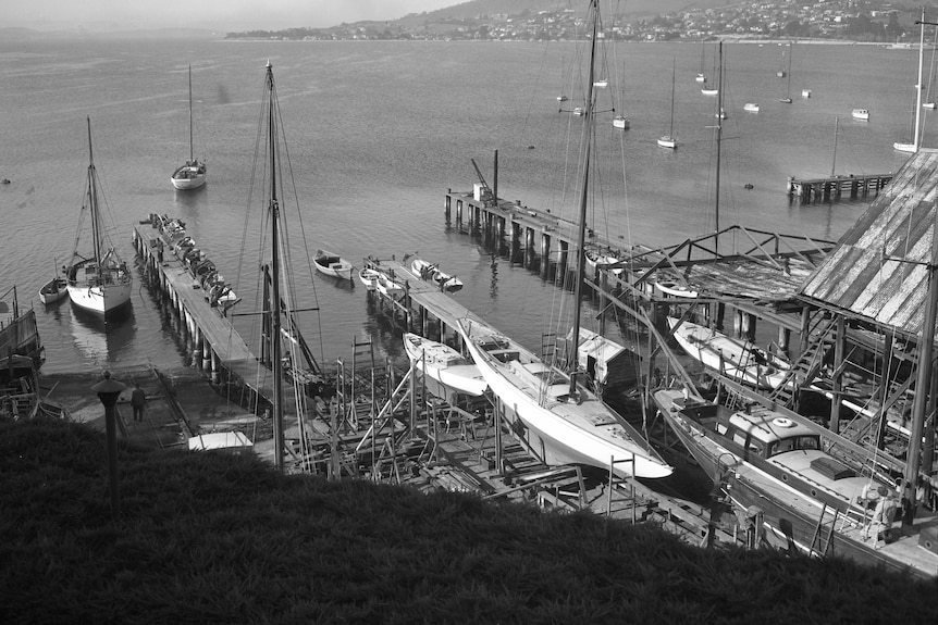 a black and white photo of a shipyard, looking out towards a bay