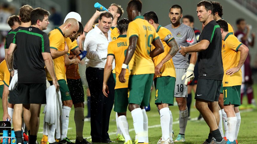 Socceroos coach Ange Postecoglou speaks to players during friendly against Qatar.