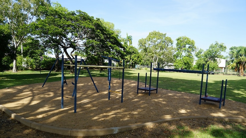A small playground with swings, a see-saw and monkey bars is pictured