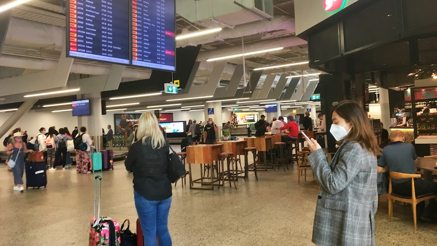 An airport with people wearing masks.