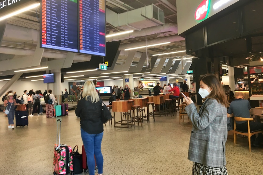 An airport with people wearing masks.