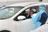 A woman wearing a Santa hat is tested for COVID-19 at a drive-through clinic in Bondi Beach on Christmas Day.