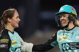 Amelia Kerr is patted on the shoulder by Georgia Redmayne after a wicket for the Brisbane Heat. Jess Jonassen is there too.