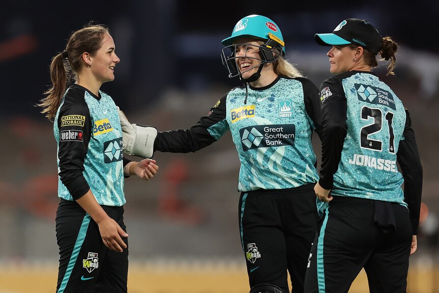 Amelia Kerr is patted on the shoulder by Georgia Redmayne after a wicket for the Brisbane Heat. Jess Jonassen is there too.