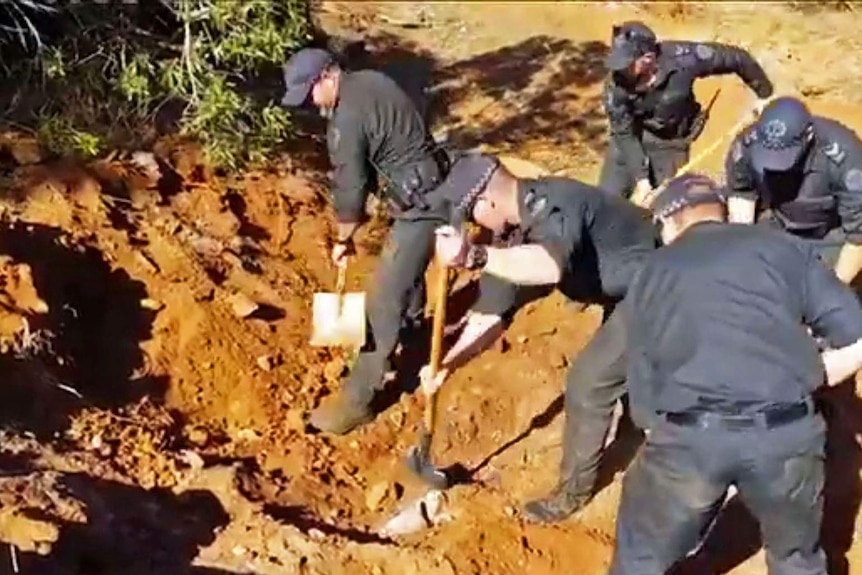 Police digging red soil.