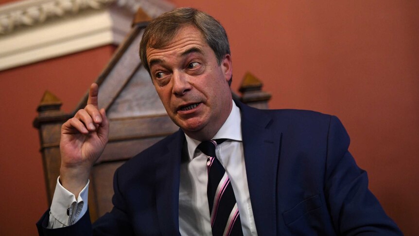Nigel Farage points his finger while delivering a speech.