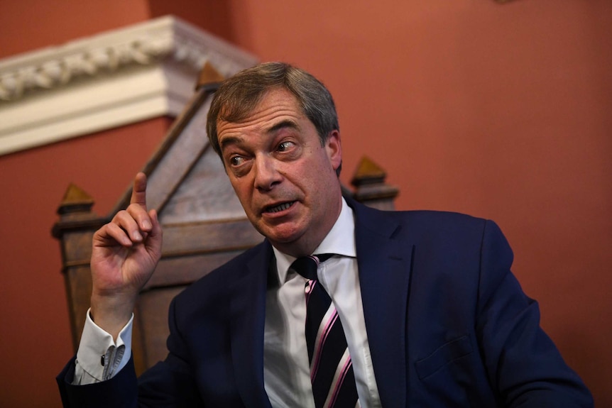 Nigel Farage points his finger while delivering a speech.