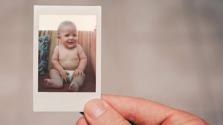 Cute photo of a smiling baby boy on a couch.