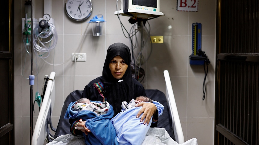 Palestinian woman Iman holds her newborn twins Uday and Hamza Abu Odah at Nasser hospital.